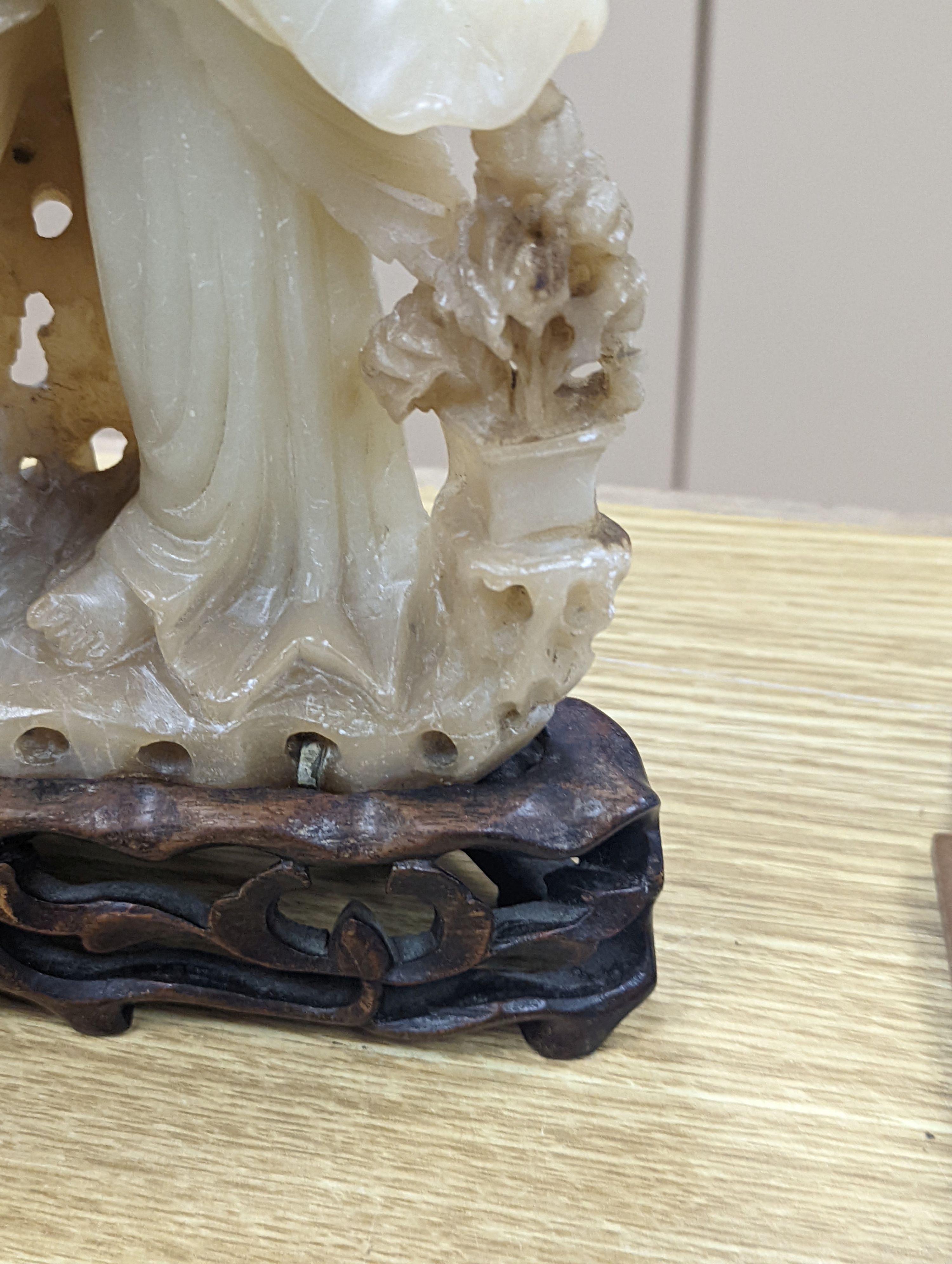 A Chinese soapstone carving of two ladies, wood stand, early 20th century, 36 cms high.